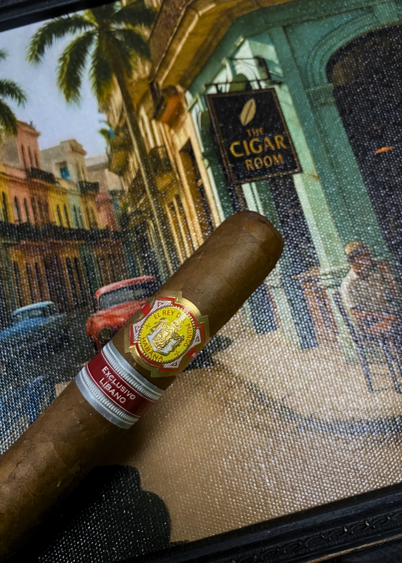 Cigar with a label held in front of a painting of 'The Cigar Room'. El Rey del Mundo W.I.H. 20 Years Regional Edition Lebanon 