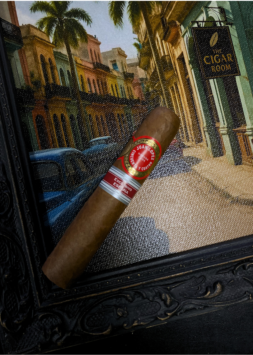 Cigar with a brand label on a textured surface, with a cityscape in the background. Juan Lopez Cincuenta y Cuatro Regional Edition Spain 2025 