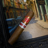 Cigar with a brand label on a textured surface, with a cityscape in the background. Juan Lopez Cincuenta y Cuatro Regional Edition Spain 2025 