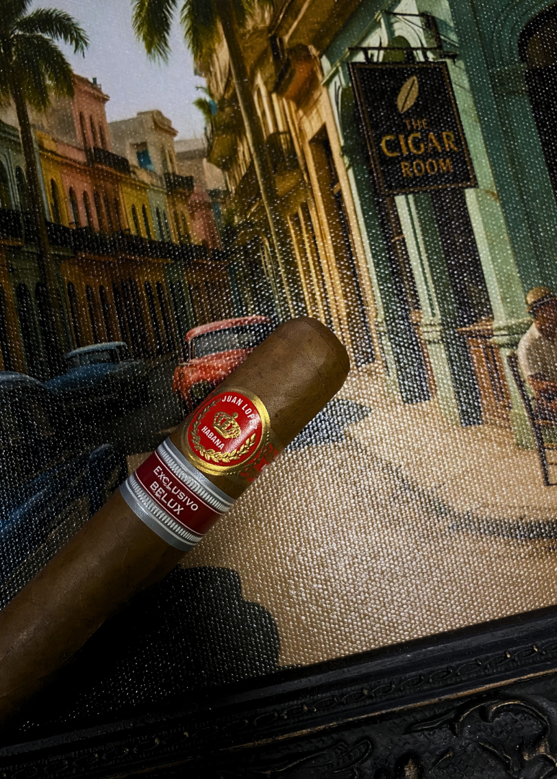 Cigar with a brand label on a textured surface featuring a street scene.