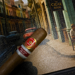 Cigar with a brand label on a textured surface featuring a street scene.