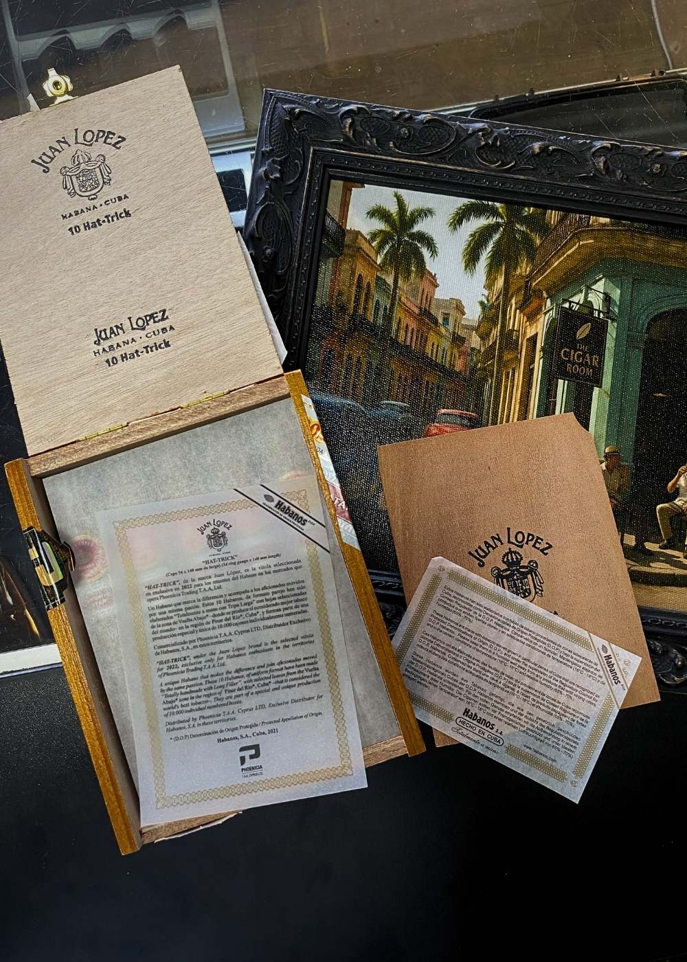 Collection of Juan Lopez documents and a framed painting on a dark surface