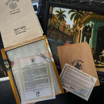 Collection of Juan Lopez documents and a framed painting on a dark surface