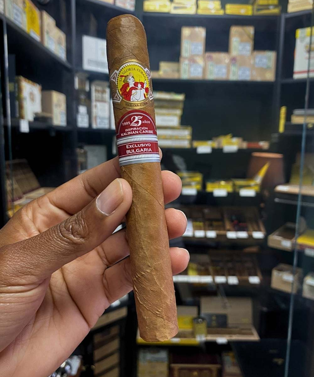 Cigar held by a hand with a blurred store shelf in the background