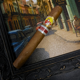 Cigar with a band on a decorative stand featuring a cityscape background