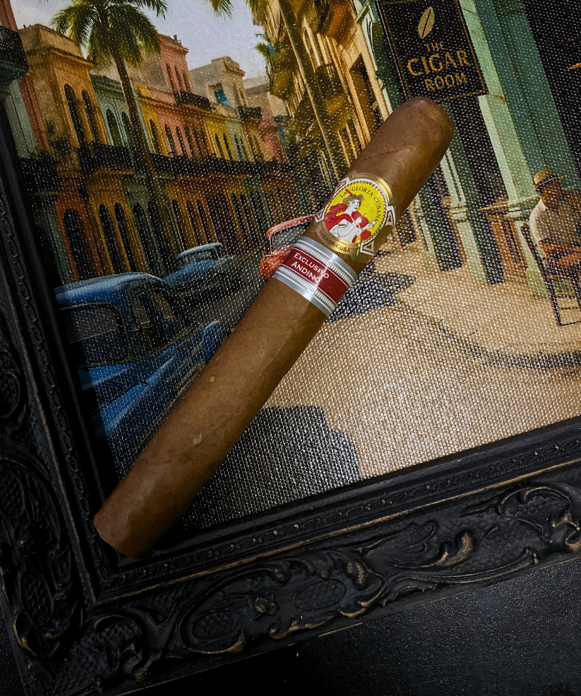 Cigar with a band on a decorative stand featuring a cityscape background