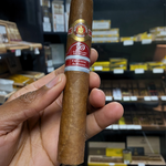 Cigar held in a hand with a blurred store shelf in the background. Ramón Allones Sr. Henry Regional Edition Germany 2020 
