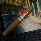 Cigar with a brand label on a decorative surface, with a cityscape in the background.Saint Luis Rey Marquéz Regional Edition Exclusive Cuba 2016