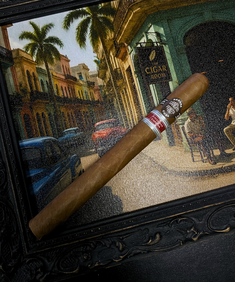 Cigar with a brand label on a decorative background of a street scene. Sancho Panza Quijote Regional Edition Spain