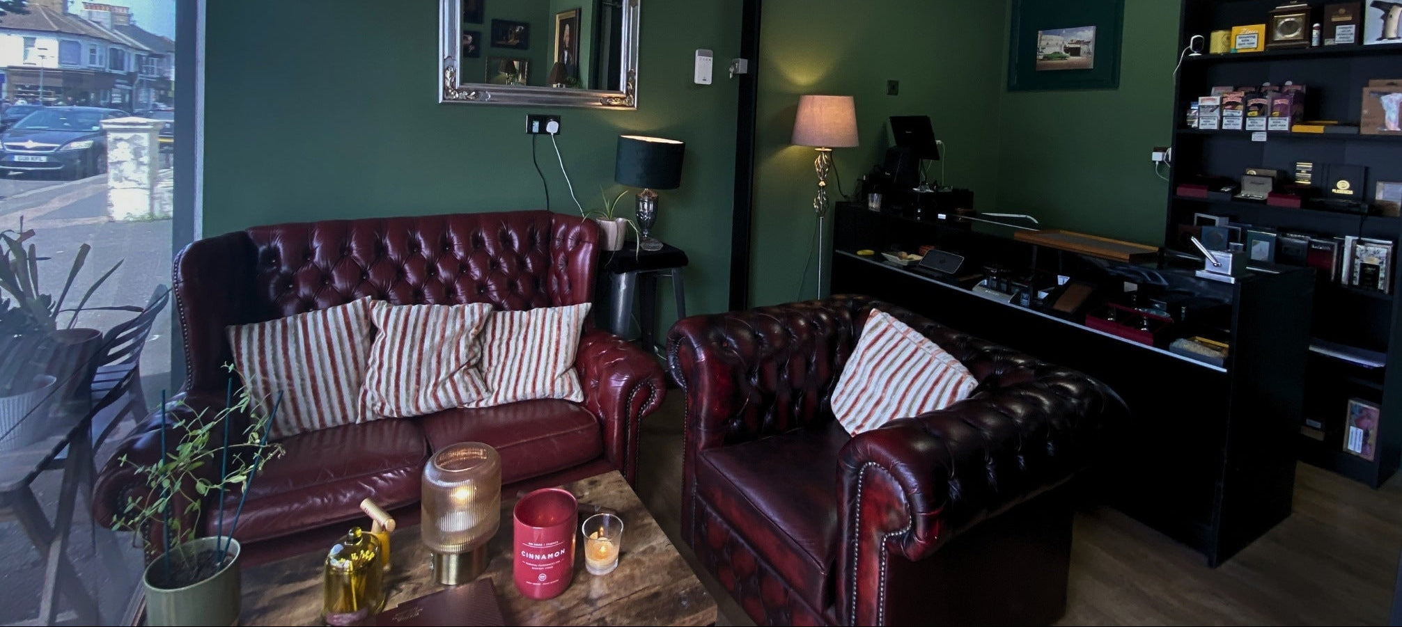 Living room with dark leather sofas, a coffee table, and decorative items.